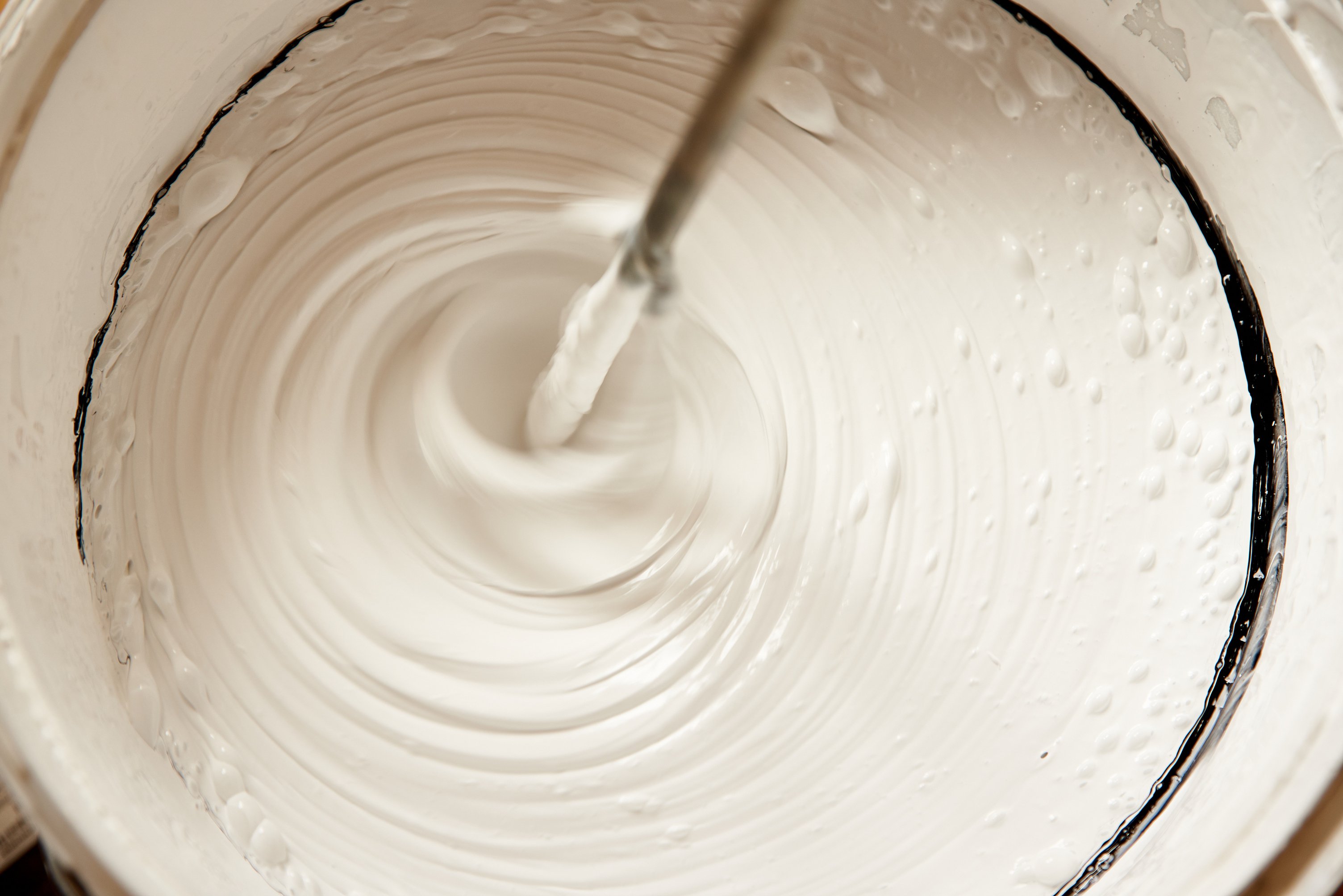 Industrial mixer mixes paint with water emulsion in a bucket